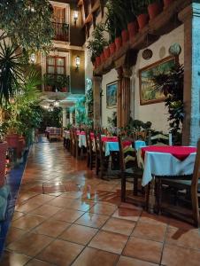 a restaurant with tables and chairs and plants at Hotel Rincon de Josefa in Pátzcuaro