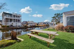 a wooden bench sitting on the grass next to a river at South Bethany --- 102 Brandywine Dr in Bethany Beach
