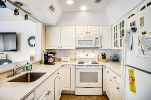 a kitchen with white cabinets and a sink and a stove at Sea Colony - 903 Singles Ct in Bethany Beach