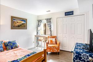 a bedroom with a bed and a chair and a door at Sea Colony - 903 Singles Ct in Bethany Beach