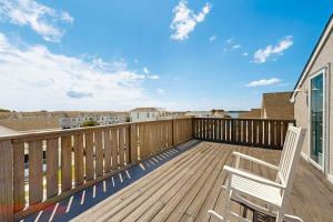 a wooden deck with a white chair on a balcony at Edgewater Acres --- 39157 Garfield Ave in Selbyville