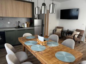 a kitchen and dining room with a wooden table and chairs at Apartmán u Fary-Harmony in Adršpach +5 photos