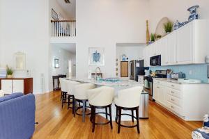 a kitchen with white cabinets and a bar with stools at Bear Trap Dunes --- 34 Sycamore Street in Ocean View