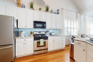 a kitchen with white cabinets and a stove top oven at Bear Trap Dunes --- 34 Sycamore Street in Ocean View +36 photos