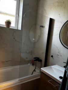 a bathroom with a tub and a sink and a mirror at Apartmán u Fary-Harmony in Adršpach