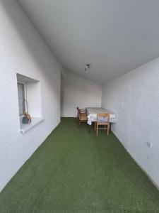 an empty room with a table and green carpet at Nektarios Apartments in Kernen