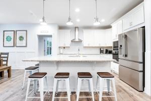 a kitchen with white cabinets and a counter with stools at Bethany West --- 557 Fairway in Bethany Beach +42 photos