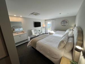 a hotel room with a large bed and a television at The Lodge at Woodstone Country Club in Danielsville