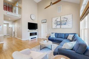 a living room with a blue couch and a tv at Bear Trap Dunes - 67 Willow Oak in Ocean View