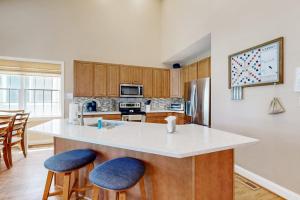 a kitchen with a white counter top and wooden cabinets at Bear Trap Dunes - 67 Willow Oak in Ocean View +42 photos