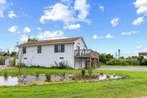 a white house with a deck on a field at Fenwick Island -- 28 High Tide in Fenwick Island