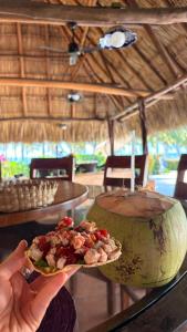 a person holding a plate of food on a table at BeachCasaDonPepe in Barra de Potosi