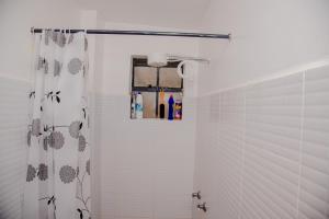 a bathroom with a shower with a shower curtain at Parma Staycation in Rungiri +55 photos