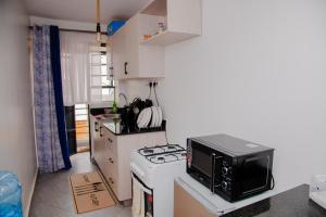 a small kitchen with a stove and a microwave at Parma Staycation in Rungiri