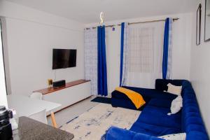 a living room with a blue couch and a tv at Parma Staycation in Rungiri