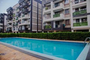 a swimming pool in front of an apartment building at Parma Staycation in Rungiri