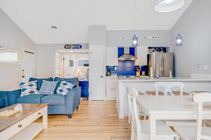 a living room with a blue couch and a kitchen at Sea Colony - 6301 Private in Bethany Beach