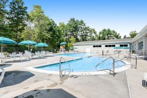 a swimming pool with tables and chairs and umbrellas at Sea Colony - 6301 Private in Bethany Beach