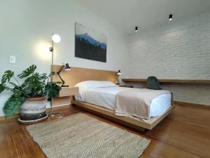 a bedroom with a large bed and a potted plant at Casa Alfredo in Mexico City