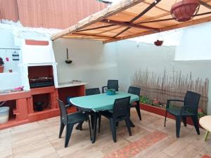 a patio with a table and chairs and a kitchen at Casa dos pais in Crato