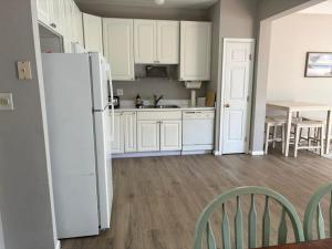 a kitchen with white cabinets and a white refrigerator at South Hampton --- 38118 E Chester Ln in Ocean View