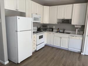 a kitchen with white cabinets and a white refrigerator at South Hampton --- 38118 E Chester Ln in Ocean View