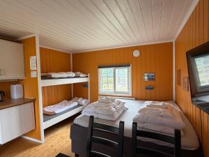 a room with two beds in it with a kitchen at Neset Skydsstasjon in Flesberg