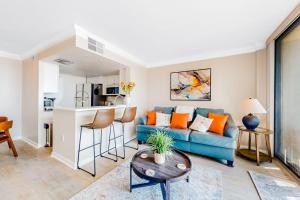 a living room with a blue couch and a kitchen at Sea Colony - 708 Brandywine House in Bethany Beach