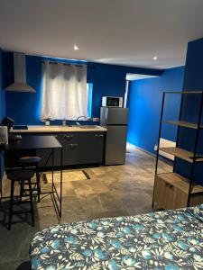 a bedroom with blue walls and a desk and a bed at Comme à la maison in Villiers-en-Bière