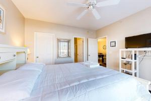 a bedroom with a large white bed with a ceiling fan at The Tides -- 20007 Sandy Bottom # 4202 in Rehoboth Beach +16 photos