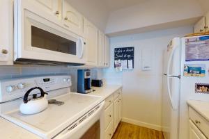 a kitchen with a white refrigerator and a tea kettle at Sea Colony - 2F Brandywine Garden Rd in Bethany Beach