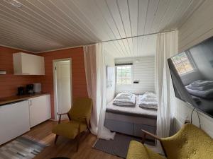 a small room with a bed and a kitchen at Neset Skydsstasjon in Flesberg