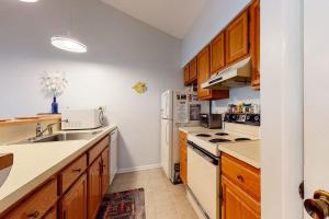 a kitchen with white appliances and wooden cabinets at Sea Colony - 9603 Timberlake in Bethany Beach +27 photos
