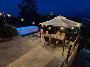 a table and chairs under an umbrella at night at Brezza di Lago in Costa Volpino
