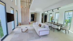 a living room with a white couch and a table at Villa Marcy in Belek