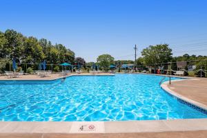 a large blue swimming pool with chairs and umbrellas at Bethany Meadows - 2A Briar North in Frankford