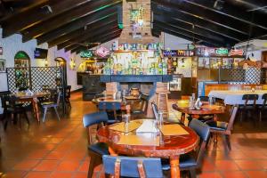 a restaurant with tables and chairs and a bar at Nobile Hotel Papillon in Bella Vista