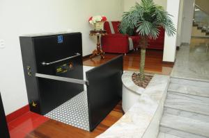 a black refrigerator in a living room with a palm tree at Colonial Palace Hotel in Pará de Minas