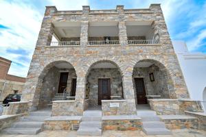 a stone building with two entrances and a balcony at Moutsouna Seaside in Moutsoúna