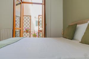 a bedroom with a white bed and an open door at Orefici's Home in Ancona