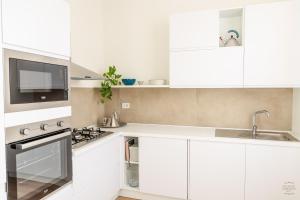 a white kitchen with white cabinets and a sink at Orefici's Home in Ancona