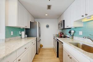 a kitchen with white cabinets and a stainless steel refrigerator at Sea Colony - 507 Georgetown House in Bethany Beach +37 photos