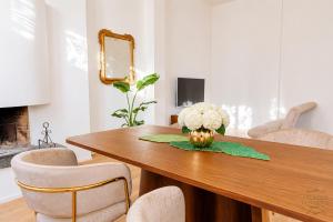 a dining room table with a vase of flowers on it at Orefici's Home in Ancona