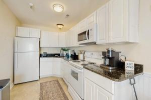 a kitchen with white cabinets and a white refrigerator at Rainbow Cove --- 117 Dagsworthy Ave #B in Dewey Beach