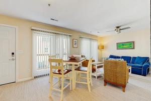 a living room with a table and a blue couch at Rainbow Cove --- 117 Dagsworthy Ave #B in Dewey Beach