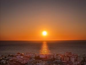 a sunset over the ocean and a city at Orefici's Home in Ancona