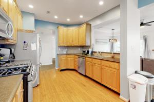 a kitchen with wooden cabinets and a white refrigerator at Bayside Bethany Lakes N Mill #114 in Ocean View +37 photos