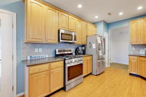 a kitchen with wooden cabinets and stainless steel appliances at Bayside Bethany Lakes N Mill #114 in Ocean View