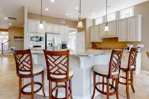 a kitchen with three bar stools and a counter at Bayside Resort --- 38958 Aster Way in Selbyville