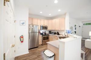 a kitchen with a stainless steel refrigerator and wooden cabinets at Bear Trap Dunes --- 45A Willow Oak in Ocean View